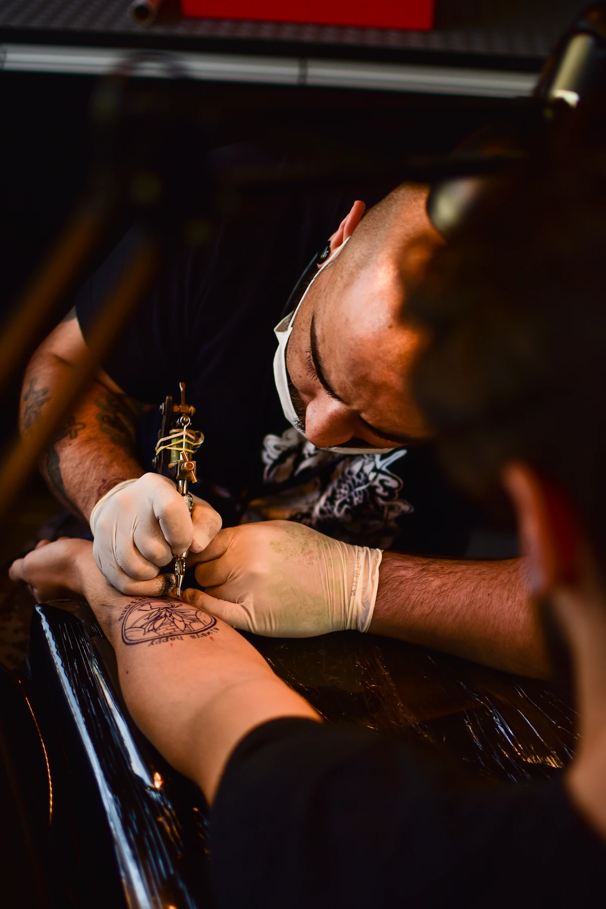 Artista trabalhando em uma tatuagem dentro de um estúdio